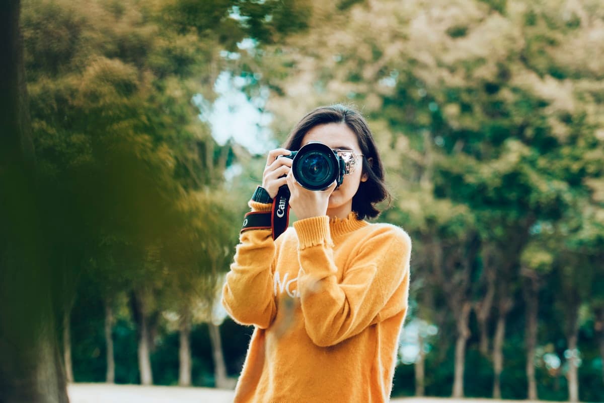 Una fotógrafa con la cámara al ojo durante una sesión al aire libre